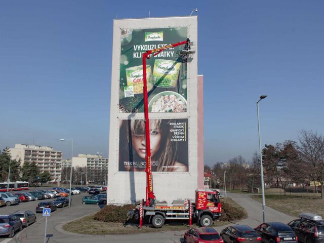 IVECO 4x4 Cela DT28 při instalaci reklamní plachty na štít panelového domu v Praze (Bohnice)